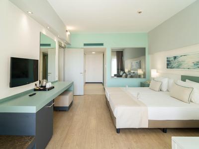 Nowoczesny pokój hotelowy z podwójnym łóżkiem, telewizorem i biurkiem.