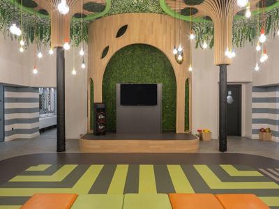 Nowoczesna, kolorowa przestrzeń eventowa z różnorodnym oświetleniem i geometrycznym wzorem dywanu.