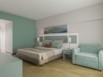 Chambre moderne avec lit double, tables de chevet, fauteuil et murs clairs.