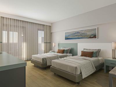 Chambre d'hôtel moderne avec deux lits simples, murs clairs et larges rideaux.