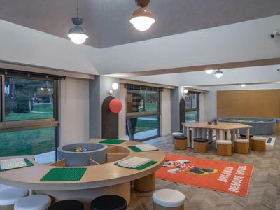 Espace lounge moderne et lumineux avec des groupes de sièges et de grandes fenêtres dans un hôtel.