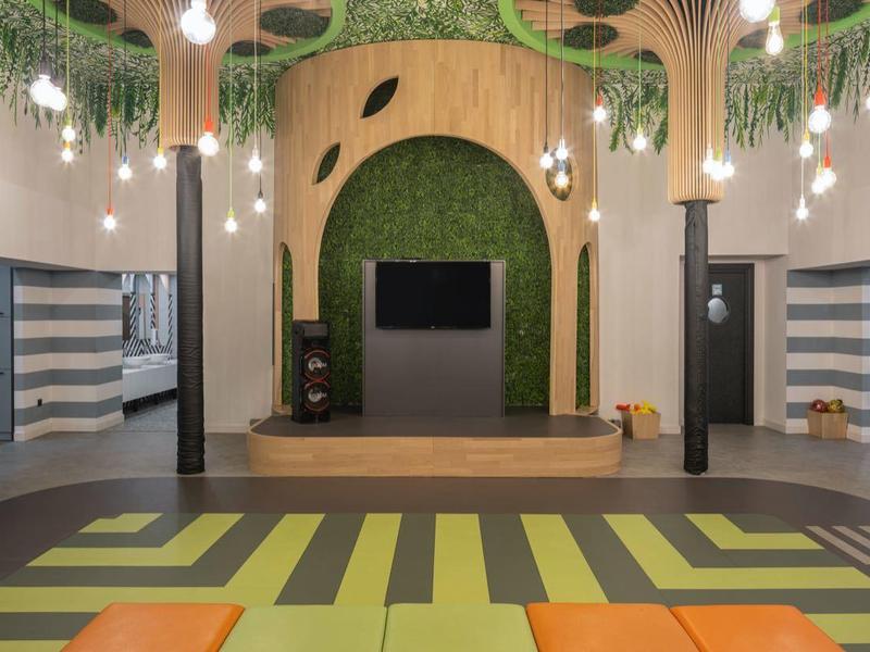 Espace événementiel moderne et colorée avec éclairage varié et motif géométrique de tapis.