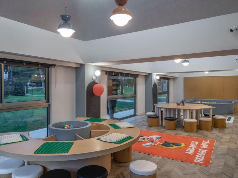 Espace lounge moderne et lumineux avec des groupes de sièges et de grandes fenêtres dans un hôtel.