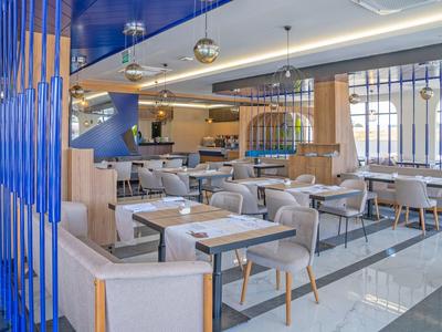 Bright, modern restaurant with comfortable chairs and elegant table settings.