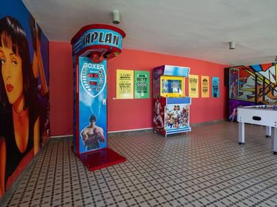 Wnętrze z automatami do gier, stołem do piłkarzyków i kolorowymi muralami