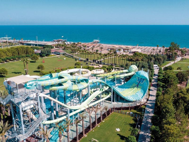 Duża zjeżdżalnia wodna z widokiem na plażę i morze w kurorcie wakacyjnym.