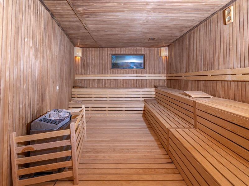 Wnętrze drewnianej sauny z ławkami i oknem.