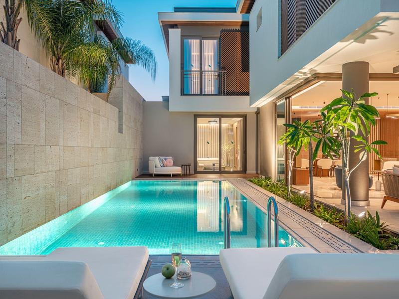 Nowoczesny basen na zewnątrz z miejscem do siedzenia i tropikalnymi roślinami w hotelu.