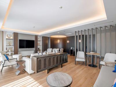 Salon moderne avec coin salon, parquet et grand téléviseur écran plat.