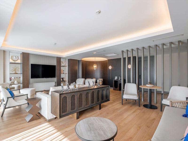 Salon moderne avec coin salon, parquet et grand téléviseur écran plat.