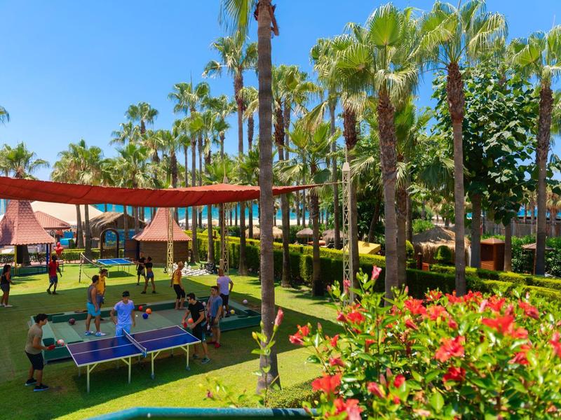 Freizeitbereich mit Trampolinen und Palmenm mit Menschen in einem Resort