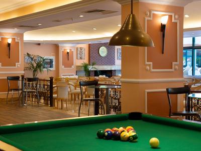 Area ricreativa elegante con tavolo da biliardo e posti a sedere in un lounge dal design accogliente.