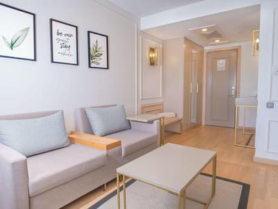 Sala luminosa con dos sofás grises, decoración de pared y mesa pequeña.