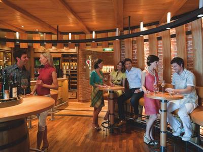 Espace bar dans un hôtel avec des clients qui discutent et dégustent des boissons.