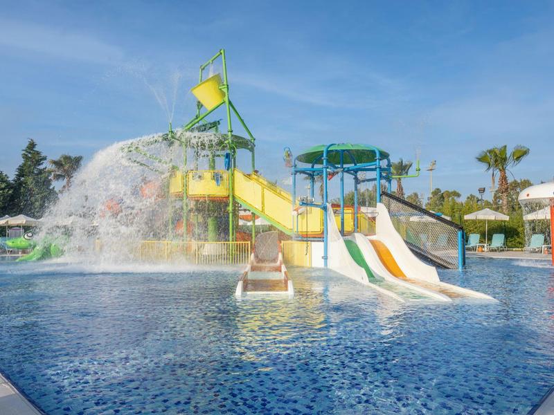 Waterpark met kleurrijke glijbanen en spattend water in het zwembad.