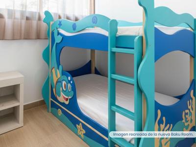 Dětská modrá patrová postel s námořnickým motivem a žebříkem vedle malé police.