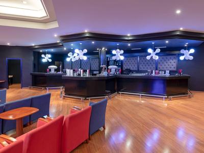 Moderne Hotelbar mit blauem Tresen, hellen Sitzgelegenheiten und Holzfußboden