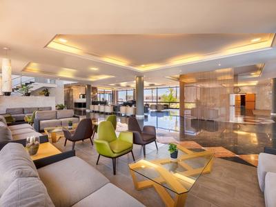 Salon d'hôtel moderne et élégant avec sièges confortables et éclairage indirect.