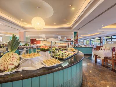 Buffet spacieux dans un restaurant lumineux avec décoration méditerranéenne et ananas frais.