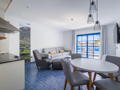 Salon et salle à manger modernes avec carrelage bleu et grande fenêtre