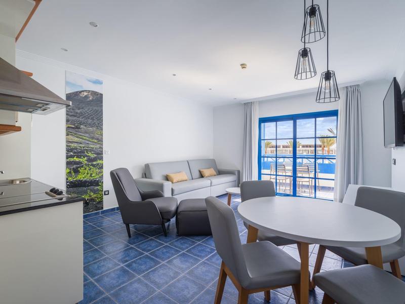 Salon et salle à manger modernes avec carrelage bleu et grande fenêtre