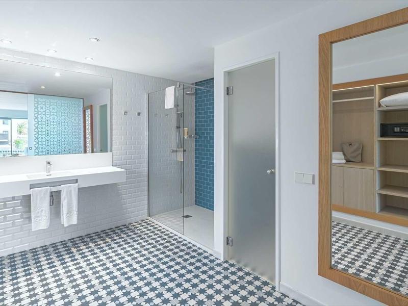 Modern bathroom with large glass shower, double sink, and large mirror.