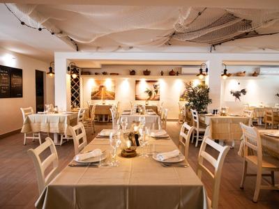 Gemütliches Restaurant mit hellen Holzmöbeln, gedeckten Tischen und warmem, dezentem Licht.