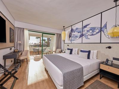 Modernes Hotelzimmer mit Doppelbett, Balkon und Meerblick.