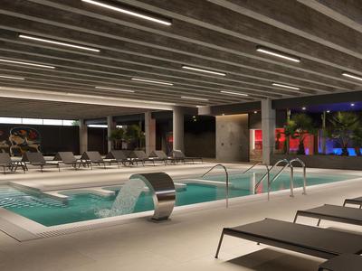 Modern indoor pool with whirlpools and loungers in a hotel