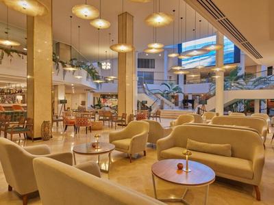 Moderner, großzügiger Hotellobby-Bereich mit bequemen Sitzmöbeln und warmem Licht.