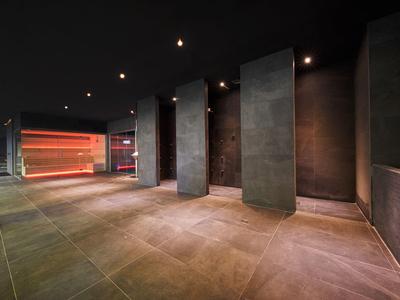 Moderner, dunkler Raum mit großem Fenster und rot beleuchtetem Bereich im Hintergrund.