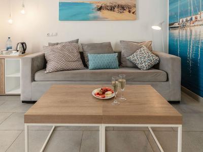 Moderner Wohnbereich mit grauem Sofa, Holztisch und maritimem Wandbild.