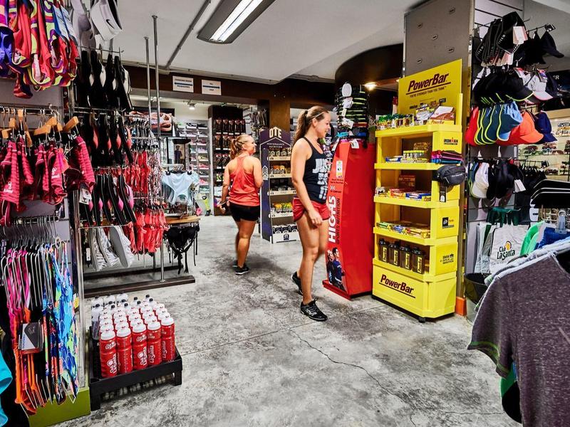 Interior of a sportswear store with racks full of clothing and customers.