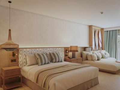 Modernes Hotelzimmer mit Doppelbett, gemütlicher Sitzgelegenheit und großen Fenstern.