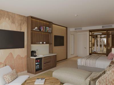 Modern eingerichtetes Hotelzimmer mit gemütlichem Sitzbereich und zwei Betten.