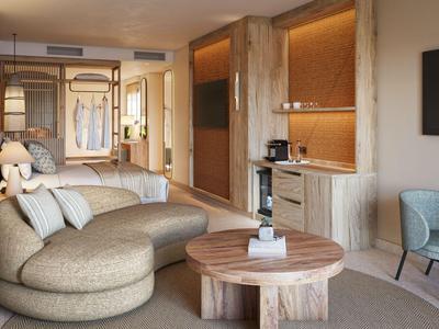 Modernes Hotelzimmer mit runder Couch, Holztisch, TV und elegantem Interieur.
