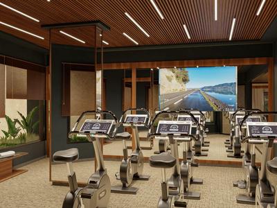 Fitnessraum eines Hotels mit mehreren Trainingsgeräten und Fenster mit Meerblick.