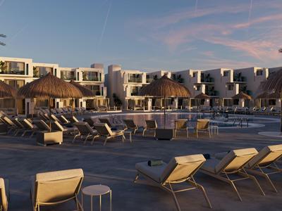 Großer Poolbereich mit Liegestühlen und Sonnenschirmen vor mehrstöckigem Hotel bei Sonnenuntergang.