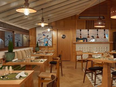 Ristorante accogliente con pareti in legno, illuminazione calda e posti a sedere confortevoli.