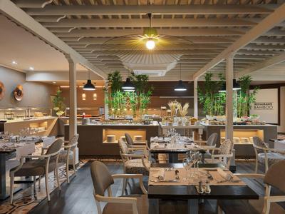 Ristorante moderno con tavoli apparecchiati e atmosfera accogliente in un interno luminoso.