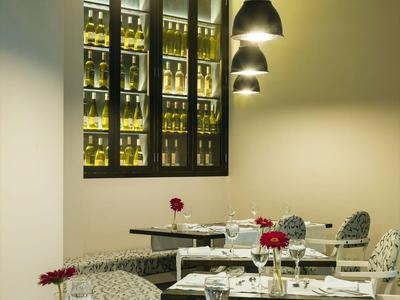 Elegante area ristorante dell'hotel con tavoli apparecchiati bianchi e illuminazione soffusa.