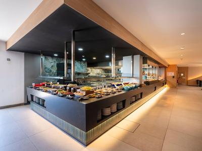 Modernes Buffet im Hotelrestaurant mit vielfältigen Speisen und eleganter Beleuchtung.