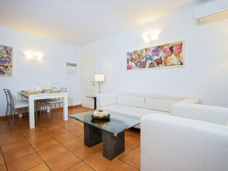 Heller Wohnbereich mit weißen Sofas, Glastisch und Esstisch in modernem Ambiente