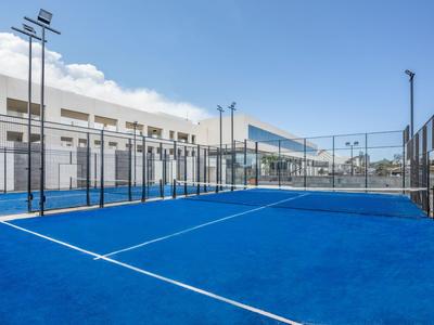 Niebieskie boisko do padla z ogrodzeniem na nowoczesnym, otwartym terenie.