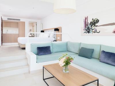 Hell eingerichtetes Wohnzimmer mit mintgrünem Ecksofa, Holztisch und weißen Wänden.