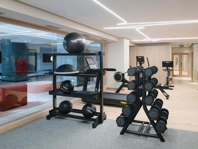 Moderne fitnessruimte met halters, gewichtrekken en spiegels in een hotel.