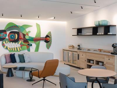 Moderne hotel-lounges met kleurrijke helikopter muurschildering, banken en tafels.