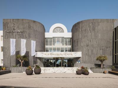 Modern hotel met ronde grijze gevel elementen en een heldere blauwe lucht.