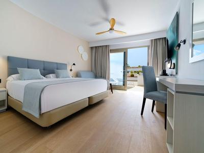 Nowoczesny pokój hotelowy z łóżkiem podwójnym, biurkiem, balkonem i widokiem na zewnątrz.