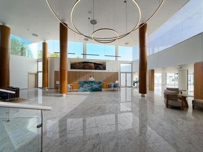 Hall d'hôtel lumineux avec sol en marbre, mobilier moderne et grandes fenêtres